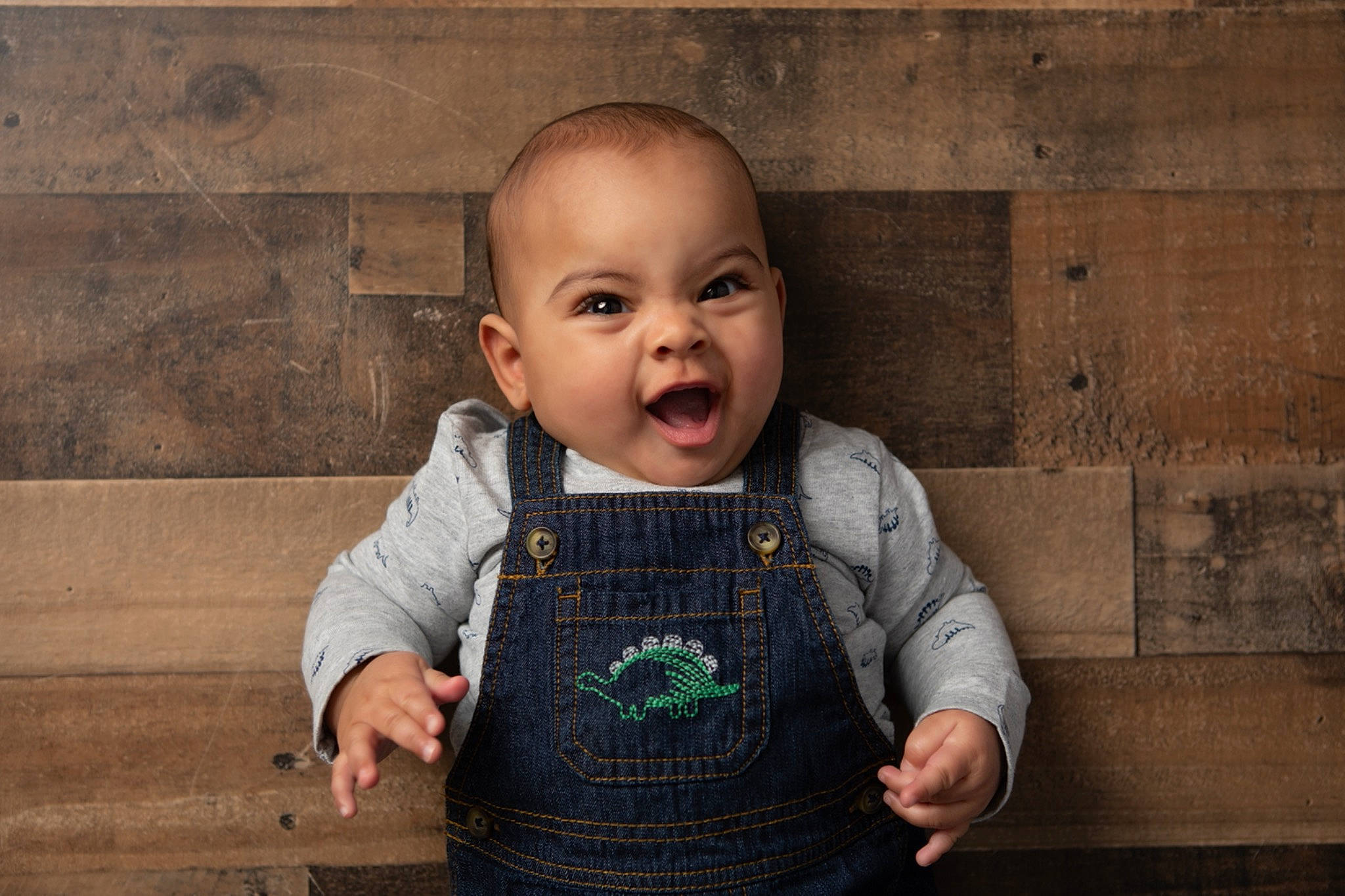 Jayden is registered to the contest to win money with this photo: baby, baby_toddler_clothing, child, eye, face, flash_photography, flooring, fun, gesture, grass, happy, iris, person, sitting, skin, sleeve, smile, standing, t_shirt, toddler