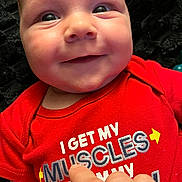 Blayze is registered to the contest to win money with this photo: apparel, baby, background, chubby_cheeks, closeup, cute, eyes, fabric, face, hand, human, infant, person, playful, portrait, red_shirt, ring, skin, smile, text_on_clothing