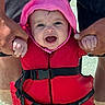 baby, child, life_jacket, water, pink_hood, smiling, happy, hands, adult, outdoor, summer, safety, playful, person, closeup, cute, bright_colors, water_sports, vacation, fun