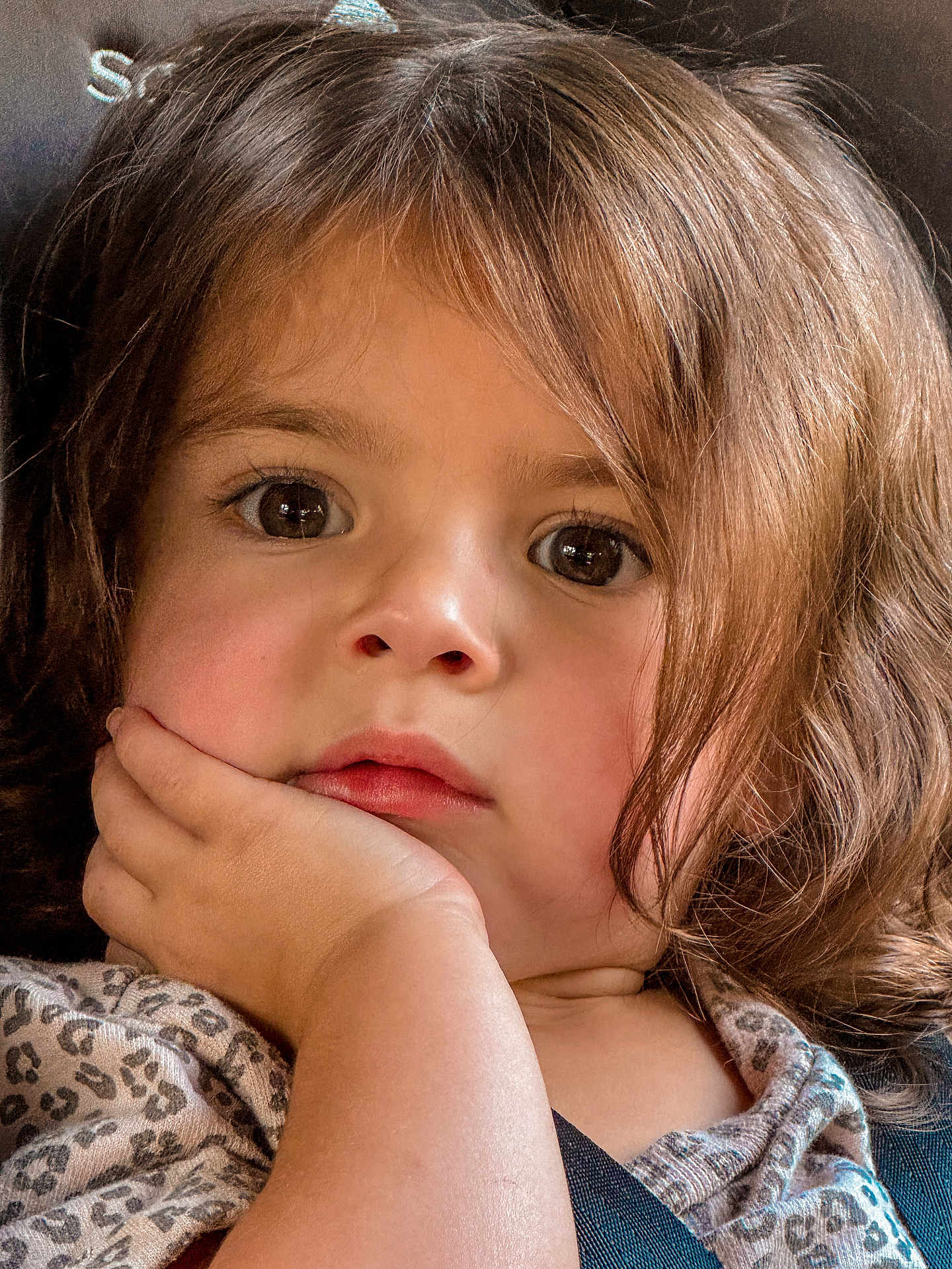 Everleigh is registered to the contest to win money with this photo: toddler, child, face, hand, brown_hair, curious, close_up, portrait, expression, young_child, skin, eyelashes, clothing, patterned_shirt, indoor, resting, cute, person, young_face, soft_light