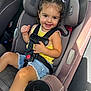 toddler, child, car_seat, smiling, yellow_top, denim_shorts, hair_buns, white_ribbons, seatbelt, car_interior, sunlight, cute, happy, portrait, safety, seat_cup_holder, car_door, window, young_child, casual_clothing