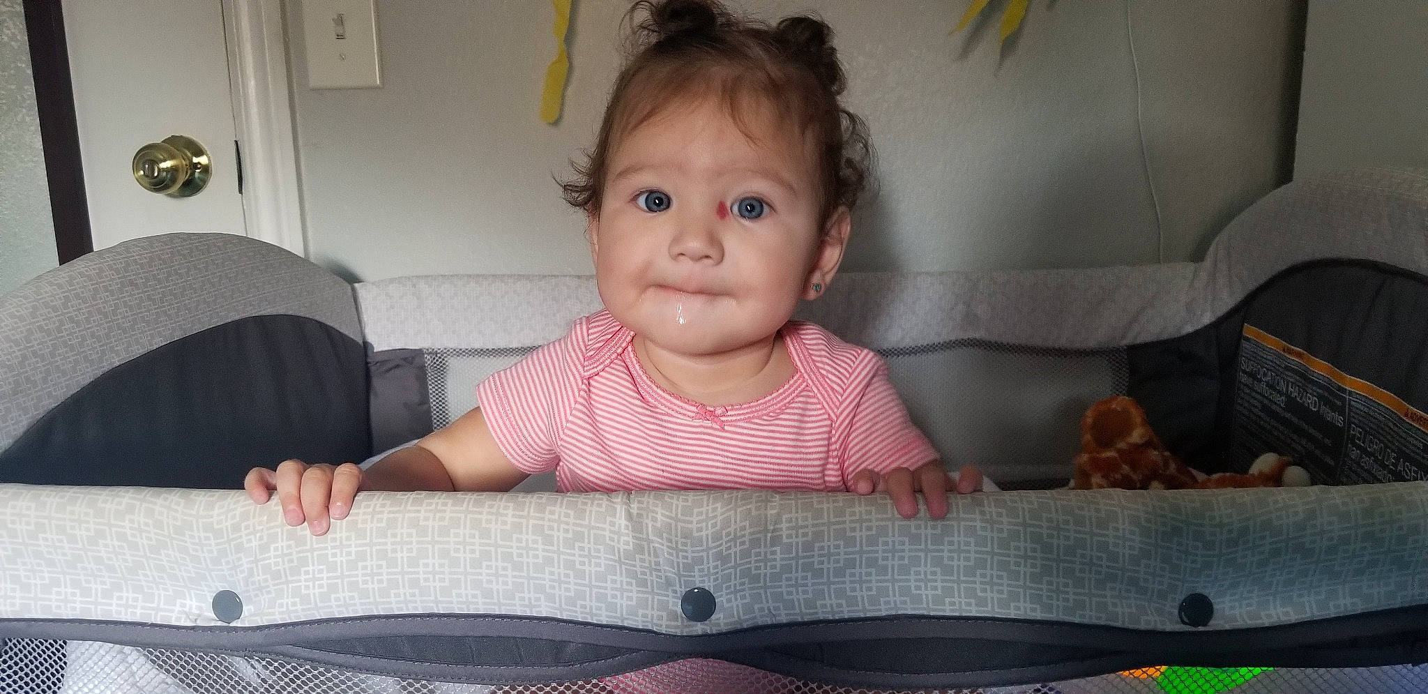 Juliette is registered to the contest to win money with this photo: baby, baby_toddler_clothing, cheek, chin, comfort, facial_expression, floor, flooring, fun, hair, head, iris, mouth, nose, person, product, skin, smile, standing, toddler