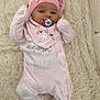 baby, infant, pacifier, pink_clothing, hat, sleepwear, blanket, soft_texture, lying_down, cute, child, indoor, fluffy_rug, small_fists, cozy, pastel_colors, face, headwear, comfort, resting