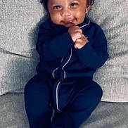 Edwin joined the competition — help win amazing prizes! baby, infant, child, smiling, couch, onesie, clothing, hands, face, happy, sitting, indoor, portrait, cozy, cute, curly_hair, comfortable, texture, sofa, home