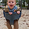 baby, child, toddler, swing, playground, outdoor, park, smiling, happy, laughing, sitting, face, portrait, infant, jacket, clothing, pants, socks, autumn_leaves, trees