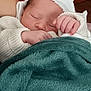 newborn, baby, sleeping, blanket, knitted_clothing, hand, cozy, soft_texture, peaceful, infant, cute, warm, resting, child, portrait, closeup, indoors, headwear, skin, relaxation