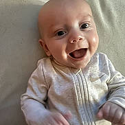 Micah is registered to the contest to win money with this photo: baby, blanket, child, clothing, cute, expression, eyes, face, happy, head, indoors, infant, joy, person, portrait, skin, smile, texture, young, zipper
