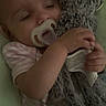 baby, pacifier, sleeping, stuffed_animal, monkey, soft_toy, blanket, infant, child, cute, cozy, clothing, rest, comfort, indoor, portrait, hand, face, toddler, bedtime