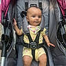baby, child, stroller, car_seat, infant, yellow_clothing, pacifier, pacifier_clip, seatbelt, cute, person, sitting, outdoor, fabric, straps, head, legs, arms, expression, comfort