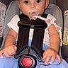 baby, child, car_seat, pacifier, pacifier_clip, blue_pants, white_shirt, seatbelt, safety, infant, cute, portrait, indoor, person, young_child, hands, face, eyes, clothing, comfort