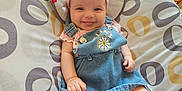 Alexis is registered to the contest to win money with this photo: baby, baby_seat, child, clothing, cute, denim_dress, furniture, happy, headband, home, indoor, infant, light, patterned_fabric, person, pink, portrait, seat, smiling, tongue_out