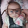 baby, car_seat, child, clothing, cute, expression, face, glasses, hand, human, indoor, infant, person, pink_cushion, plush, portrait, seatbelt, sitting, wide_eyes, young