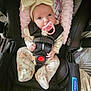 Alexis is registered to the contest to win money with this photo: baby, black, bow, car_seat, child, clothing, cushion, cute, headband, indoors, infant, pacifier, patterned, person, pink, safety, seatbelt, sitting, strap, young