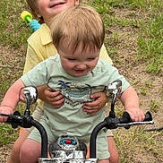 Cody is registered to the contest to win money with this photo: casual_clothing, child, children, cute, daylight, footwear, fun, grass, happy, nature, outdoor, play, playtime, shorts, siblings, smiling, summer, toy_motorcycle, tshirt, two_kids