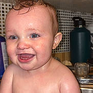 Cody is registered to the contest to win money with this photo: baby, child, wet_hair, mohawk, smile, kitchen, sink, blue_eyes, skin, arm, face, happy, indoors, water, person, expression, cute, chubby, closeup, funny_hairstyle