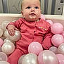 baby, child, pink_outfit, ball_pit, plastic_balls, indoor, cute, portrait, infant, playtime, soft_toys, happy, childhood, smiling, face, hand, seated, looking_up, cozy, adorable