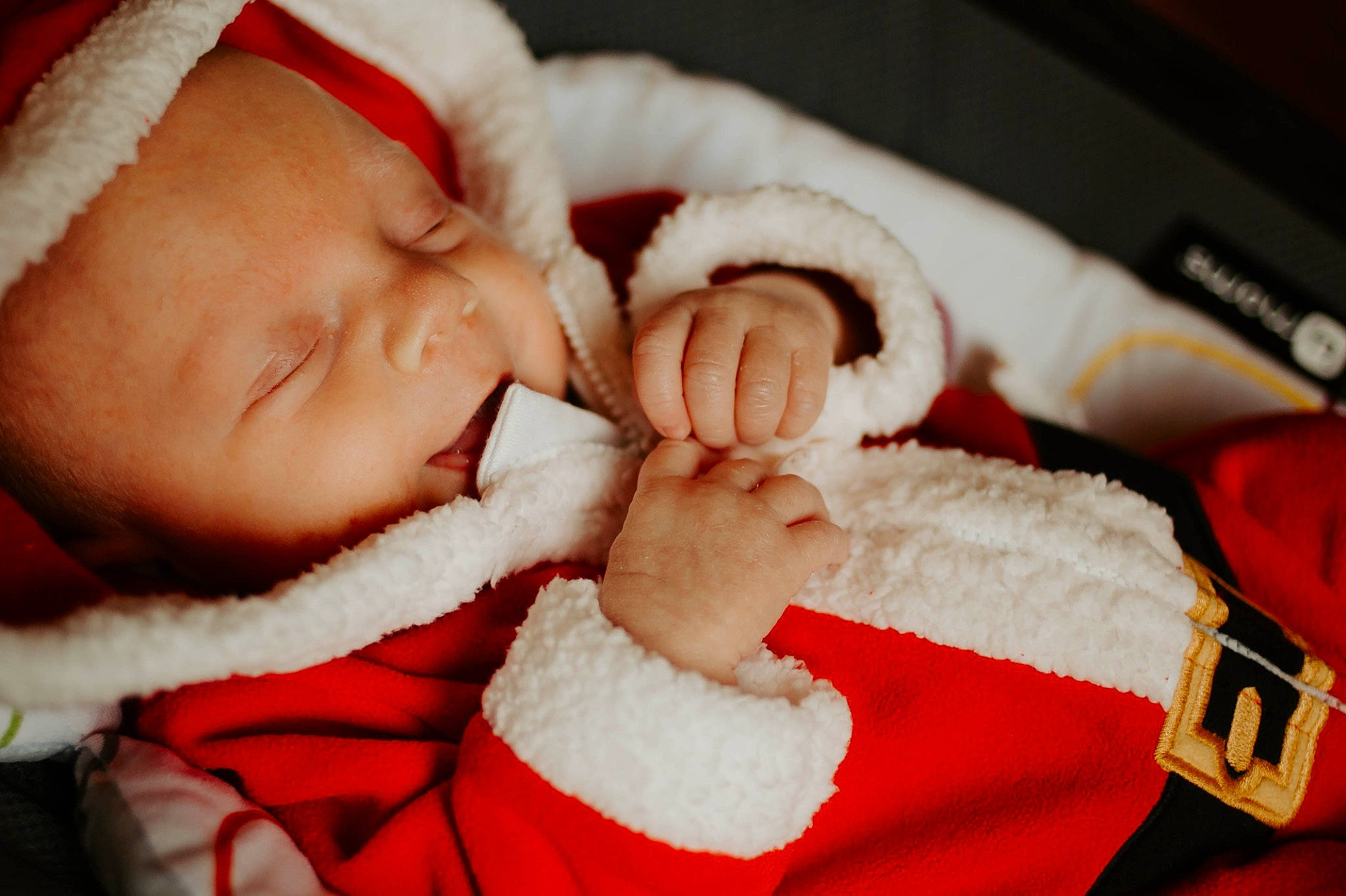 Cam is registered to the contest to win money with this photo: baby, baby_sleeping, baby_toddler_clothing, cheek, comfort, eye, fictional_character, finger, fur_clothing, gesture, hand, happy, human_body, lip, mouth, nose, person, santa_claus, skin, smile