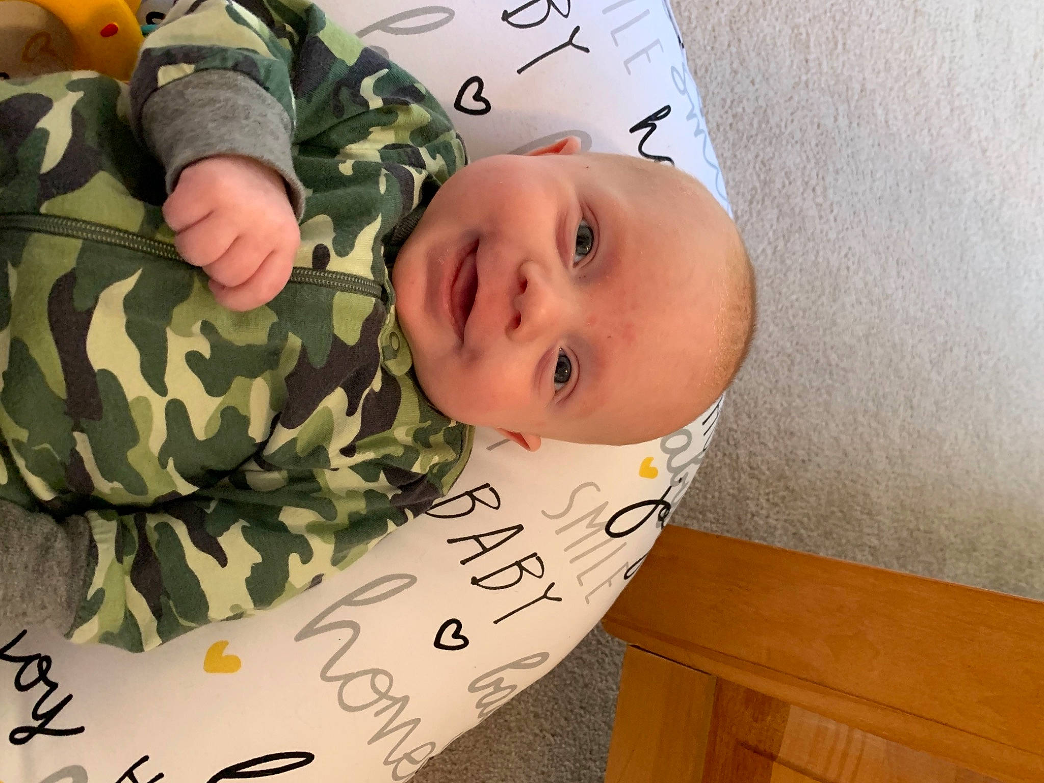 Cam is registered to the contest to win money with this photo: baby, baby_products, baby_safety, baby_toddler_clothing, camouflage, child, comfort, gesture, happy, hardwood, military_camouflage, military_person, military_uniform, pattern, person, sleeve, smile, soldier, toddler, wood