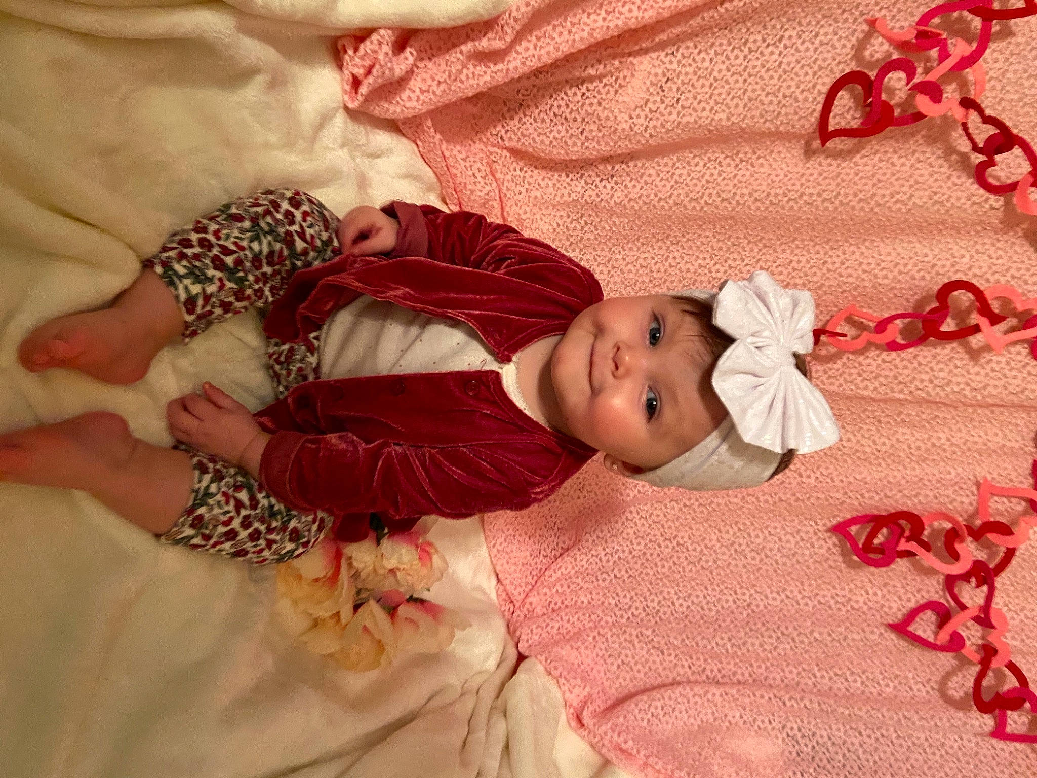 Josie is registered to the contest to win money with this photo: baby, baby_toddler_clothing, cheek, child, comfort, creative_arts, embellishment, fashion_accessory, hair_accessory, happy, head, headwear, joy, linens, magenta, pattern, peach, person, pink, product