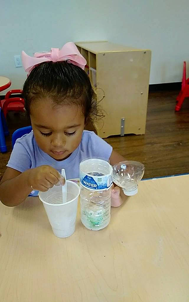 Kayleigh joined the competition — help win amazing prizes! chair, child, cooking, drink, drinkware, flooring, fun, person, plastic, plastic_bottle, play, room, sand, school, science, shipping_box, t_shirt, table, toddler, water