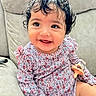 baby, child, infant, smiling, happy, portrait, curly_hair, floral_dress, patterned_clothing, pacifier, sitting, sofa, couch, indoor, close_up, face, eyes, playful, 家庭, photography