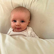 Avoye a rejoint le concours — aidez-le/la à gagner de superbes lots ! baby, infant, blanket, bed, white, face, eyes, smile, cute, child, sleepwear, soft, cozy, portrait, skin, head, lying_down, newborn, indoors, comfort