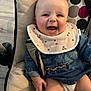 baby, bib, cheeks, child, clothing, cushion, denim, eyes, face, hand, happy, head, indoor, infant, legs, mouth, person, seat, skin, smiling