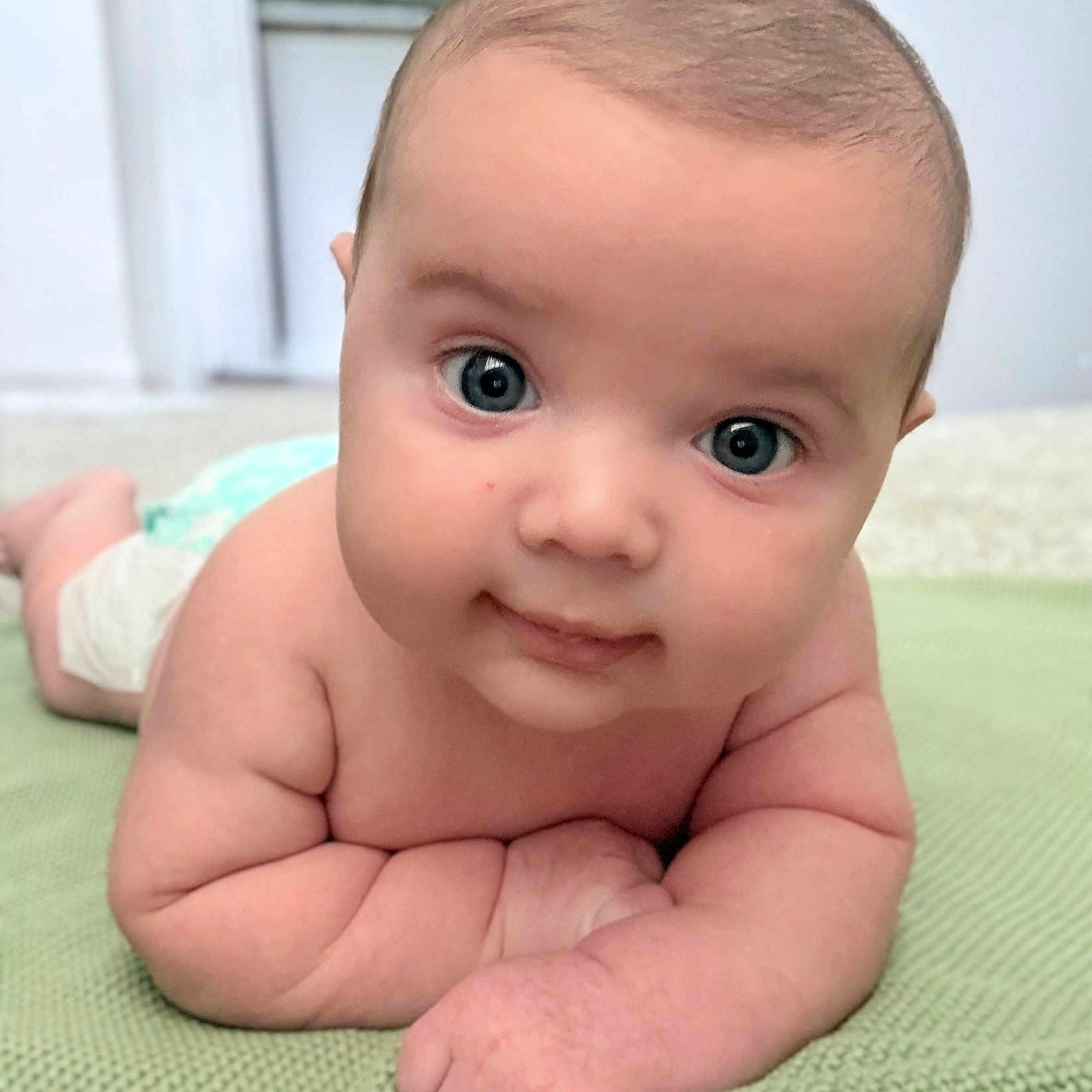 Jaxson is registered to the contest to win money with this photo: baby, infant, child, cute, face, blue_eyes, skin, lying_down, blanket, close_up, portrait, chubby, smile, hands, arms, soft_light, indoor, expression, head, person