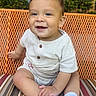 baby, child, smiling, sitting, cushion, striped, orange_chair, outdoor, happy, face, sock, white_clothing, short_sleeve, cute, young_child, infant, portrait, daylight, greenery, metal_chair