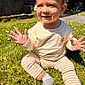 Lucca is registered to the contest to win money with this photo: toddler, child, grass, sunlight, smile, hands, sitting, outdoor, pants, sweater, bear_patch, face, head, person, footwear, sock, daylight, background, garden, happy