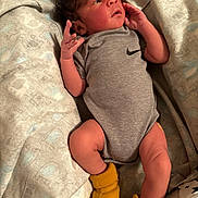 Jayce joined the competition — help win amazing prizes! baby, newborn, infant, onesie, grey_clothing, yellow_socks, blanket, patterned_blanket, lying_down, indoor, human, cute, small_hands, curious_expression, soft_lighting, close_up, portrait, resting, toddler, baby_clothes