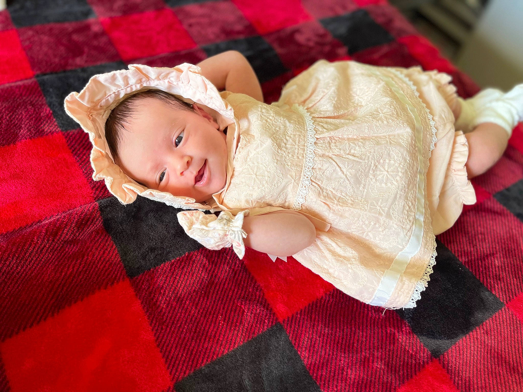 Amaya is registered to the contest to win money with this photo: baby, baby_toddler_clothing, child, comfort, dress, finger, flooring, happy, hat, magenta, pattern, person, pink, plaid, red, skin, sleeve, tartan, textile, toddler