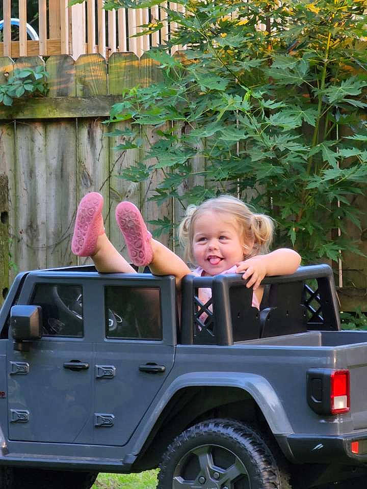 Presleigh is registered to the contest to win money with this photo: automotive_design, automotive_tire, bumper, car, clothing, grass, green, hand, hood, joy, mammal, motor_vehicle, person, photograph, plant, smile, tire, tread, vehicle, vehicle_door