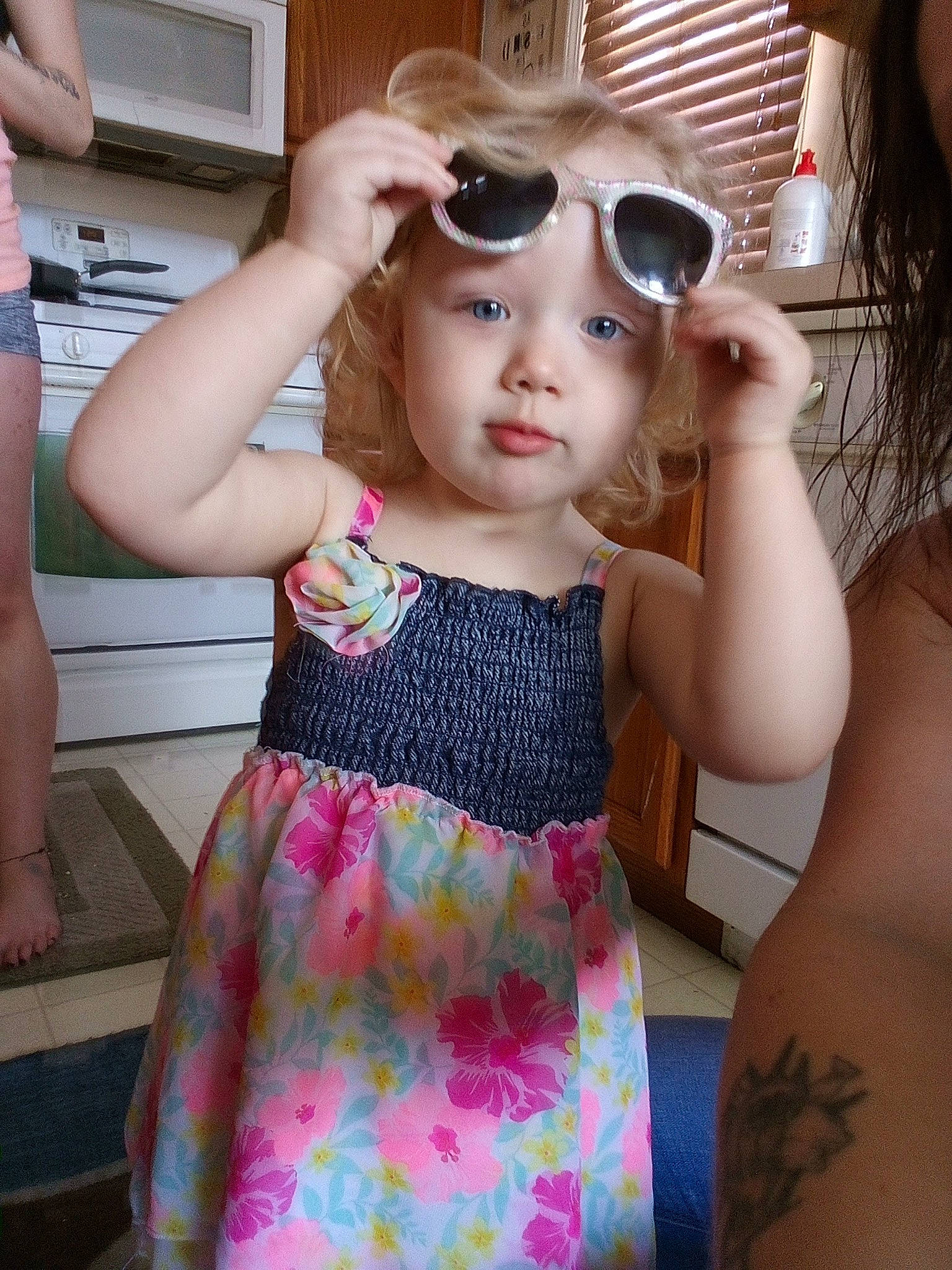 Brooklyn is registered to the contest to win money with this photo: baby_toddler_clothing, day_dress, eyewear, face, facial_expression, finger, fun, gesture, goggles, hand, happy, joint, one_piece_garment, person, pink, skin, sleeve, sunglasses, toddler, vision_care