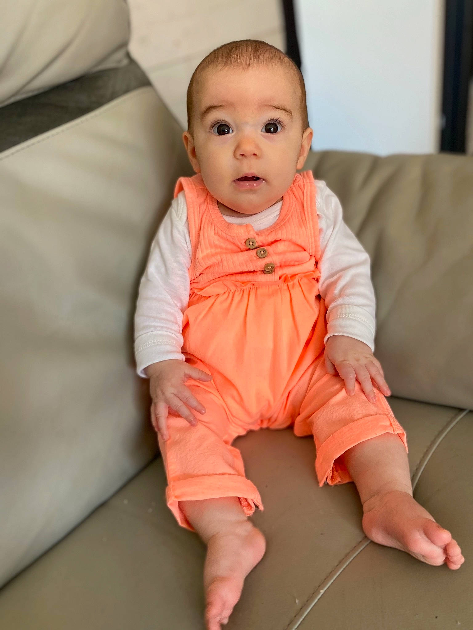Kaily participe au concours pour gagner de l'argent avec cette photo : baby, baby_toddler_clothing, barefoot, cheek, collar, comfort, eye, face, finger, floor, flooring, foot, happy, human_body, nose, orange, person, skin, sleeve, smile