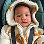 baby, child, hoodie, fluffy_clothing, seatbelt, car_seat, blanket, infant, cute, face, portrait, warm_clothing, baby_garment, seated, comfort, young_child, soft_texture, casual, indoor, closeup