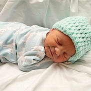 Elijah joined the competition — help win amazing prizes! newborn, baby, sleeping, hat, knit_hat, onesie, giraffe_pattern, blanket, soft, cozy, infant, cute, peaceful, resting, portrait, child, clothing, indoors, closeup, toddler