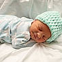 newborn, baby, sleeping, hat, knit_hat, onesie, giraffe_pattern, blanket, soft, cozy, infant, cute, peaceful, resting, portrait, child, clothing, indoors, closeup, toddler