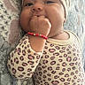 Celeste is registered to the contest to win money with this photo: baby, blanket, bracelet, child, close_up, cozy, cute, eyes, face, fist, hand, headwrap, indoors, infant, leopard_print, lying_down, outfit, portrait, smiling, turban