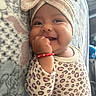 Celeste joined the competition — help win amazing prizes! baby, blanket, bow, bracelet, candid, child, close_up, eyes, face, fist, hand, happy, headwrap, indoor, infant, leopard_print, lying_down, onesie, portrait, smiling