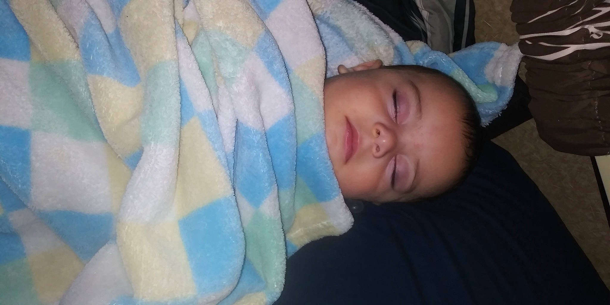 Hugo is registered to the contest to win money with this photo: baby, baby_products, baby_toddler_clothing, cheek, child, comfort, electric_blue, eye, eyebrow, hand, head, iris, linens, nap, pattern, person, room, sitting, skin, sleep