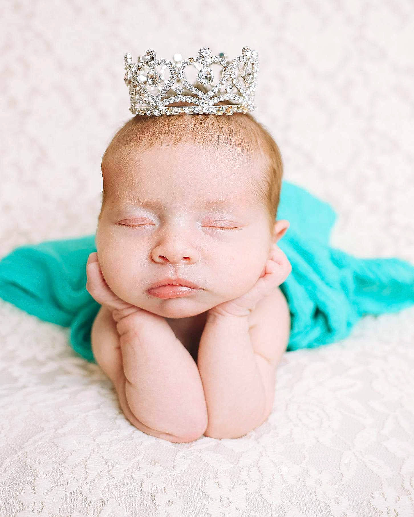 Bella is registered to the contest to win money with this photo: baby, baby_toddler_clothing, comfort, ear, eye, eyebrow, eyelash, face, fashion_accessory, hair_accessory, happy, head, headband, headgear, headpiece, jewellery, pattern, person, skin, tiara