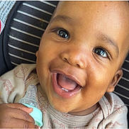 Nasir joined the competition — help win amazing prizes! baby, bottle, child, smiling, happy, face, infant, cute, teeth, hand, clothing, seat, striped, skin, mouth, portrait, closeup, young, holding, expression