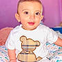 baby, big_eyes, candid, child, clothing, colorful, comfort, cute, happy, indoors, light_skin, plaid_pattern, portrait, short_hair, sitting, smile, soft_background, teddy_bear, white_shirt, young_child