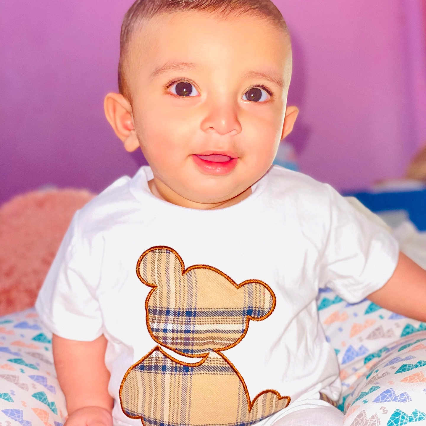 Muhammad Ali a rejoint le concours — aidez-le/la à gagner de superbes lots ! baby, big_eyes, candid, child, clothing, colorful, comfort, cute, happy, indoors, light_skin, plaid_pattern, portrait, short_hair, sitting, smile, soft_background, teddy_bear, white_shirt, young_child