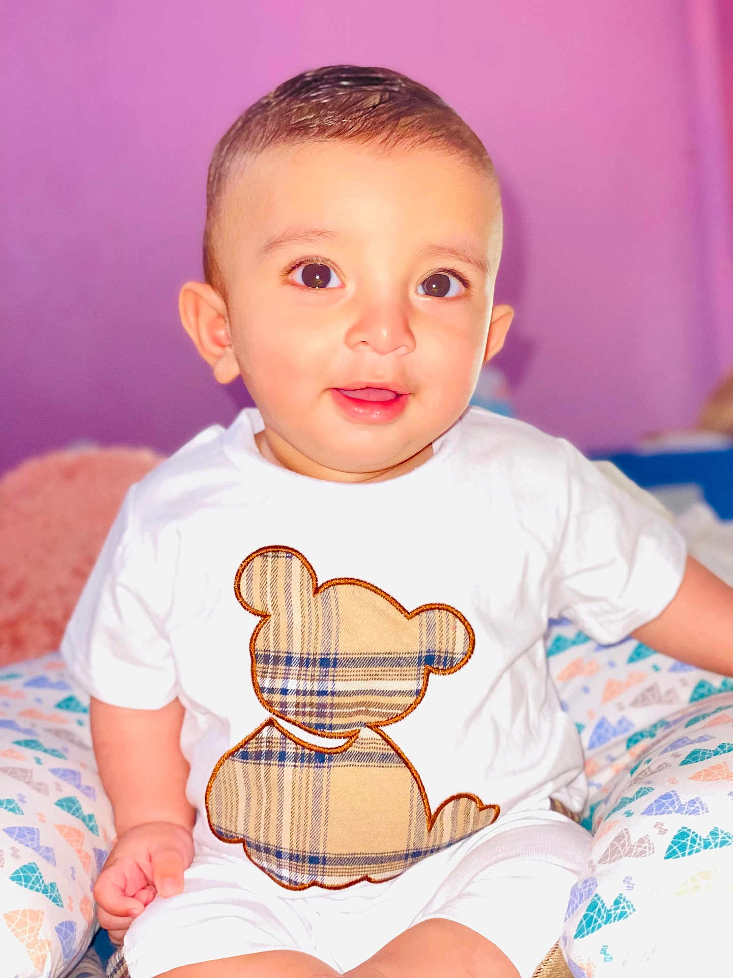 Muhammad Ali a rejoint le concours — aidez-le/la à gagner de superbes lots ! baby, big_eyes, candid, child, clothing, colorful, comfort, cute, happy, indoors, light_skin, plaid_pattern, portrait, short_hair, sitting, smile, soft_background, teddy_bear, white_shirt, young_child