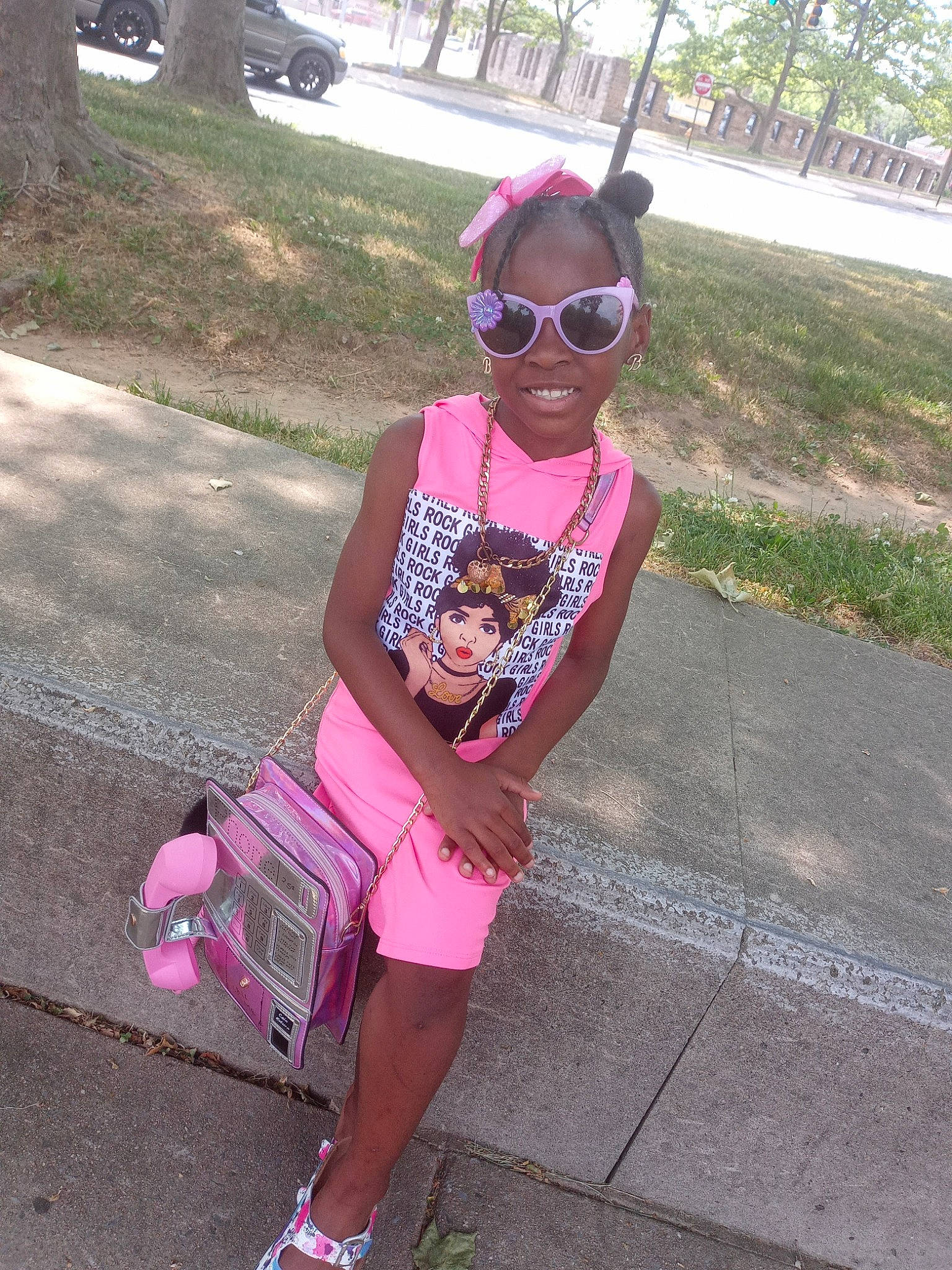 Julie is registered to the contest to win money with this photo: asphalt, bag, cool, eyewear, glasses, goggles, hairstyle, joy, leisure, luggage_and_bags, person, pink, plant, sleeve, smile, street_fashion, sunglasses, t_shirt, textile, tree