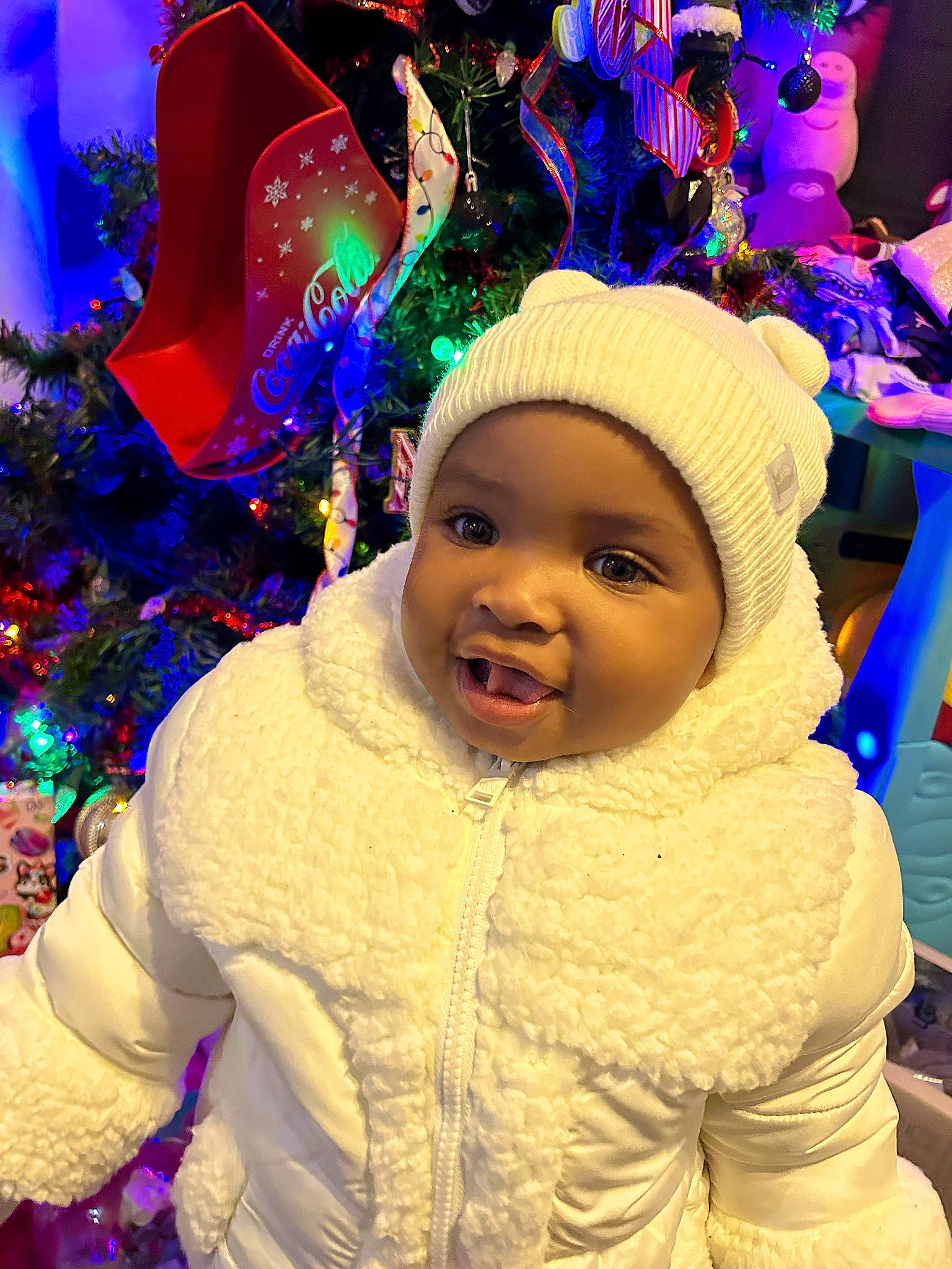 Faith joined the competition — help win amazing prizes! cap, child, christmas, christmas_decoration, christmas_ornament, christmas_tree, costume_hat, event, facial_expression, fun, happy, headgear, headwear, holiday, human_body, jacket, light, magenta, person, purple