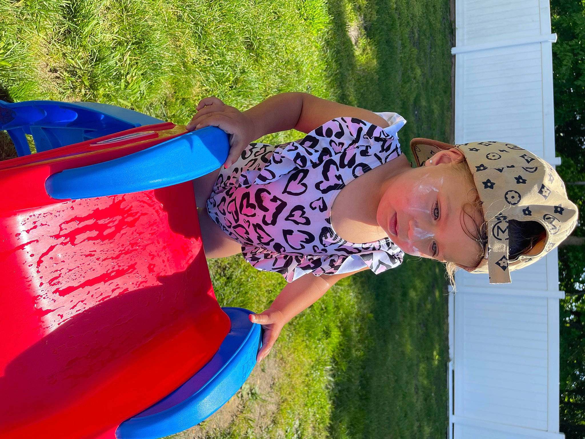 Italia is registered to the contest to win money with this photo: child, electric_blue, fashion_accessory, fun, grass, happy, hat, headwear, leisure, magenta, pattern, people_in_nature, person, plant, recreation, shade, sun_hat, textile, tints_and_shades, toddler