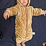 Shahzain is registered to the contest to win money with this photo: baby, child, onesie, plush, fuzzy, costume, face, feet, hands, blanket, lying_down, cute, infant, expression, indoor, clothing, hood, portrait, soft, warm